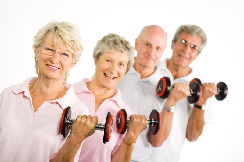 Image of four elder people lifting weights in a row.