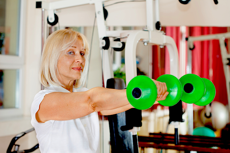 woman lifting green weights