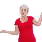 an older woman in a red shirt holds her hands unevenly in the air to demonstrate a lack of balance