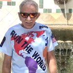 an older man wearing sunglasses and a T-shirt with the words "Run the World" printed on it