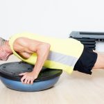 A man working out with a half balance ball