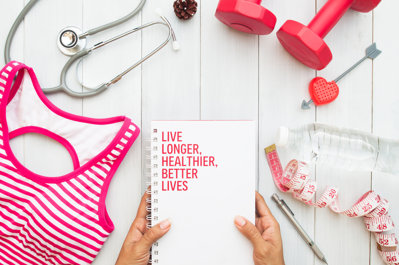 photo of gym and health equipment and a notebook that says Live Longer, Healthier, Better Lives